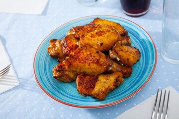 grill spicy buffalo wings on blue plate for lunch