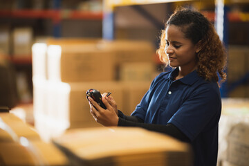 warehouse worker using bar code scanner to analyze newly arrived goods for further placement in...