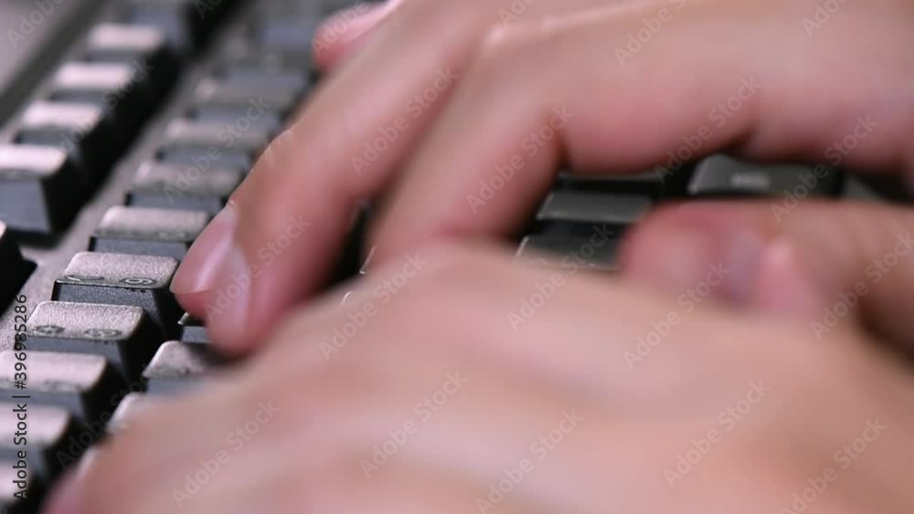 Poster extreme close-up on the computer keyboard while typing on it.