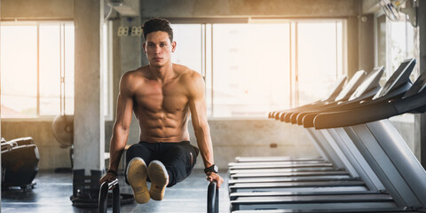 handsome and strong young man working out, Doing intense exercise in the sport gym, Attractive tall...