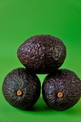  avocado set. Dark brown avocado fruit on a bright green background. Eco-friendly organic farm product. Vegan and vegetarian food. Super food.