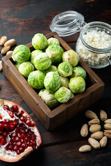 Brussels sprouts, with pomegranate, cottage cheese and pistachios, on old wooden table