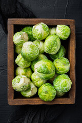 Brussels sprouts, on black textured background, flat lay