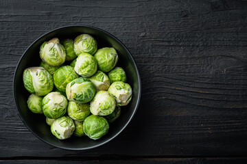Brussels sprouts, on black wooden table, top view with space for text