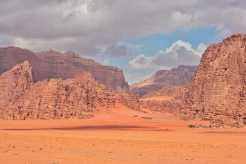 beautiful landscape of the Wadi Ram desert in Jordan, a small bedouin camp is located at the foot of the mountains, beautiful clouds in the sky
