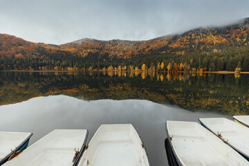 Fototapeta na wymiar Colorful autumn landscape.Nature background.Boat on the lake in the autumnal forest
