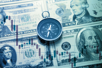 Chart graph spreadsheet on US dollar banknotes money with compass. Choosing the direction.