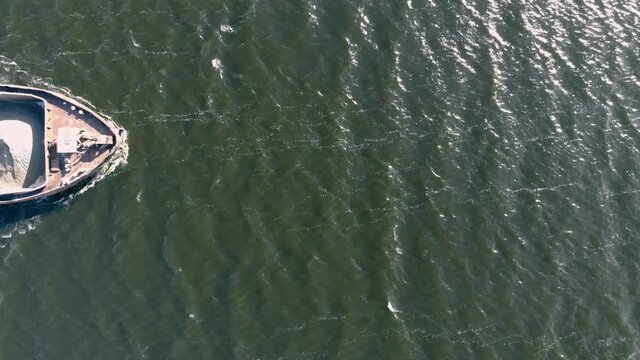 A dump scow transports sand&nbsp;down&nbsp;the river