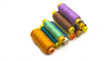 A pyramid of various colors of sewing thread roll on an isolated white background.