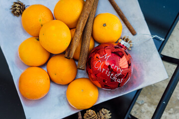 Still life with chrostmas decoration, tangerine and cones on the silver plate