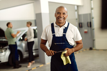 Portrait of happy black mechanic working at auto repair shop.