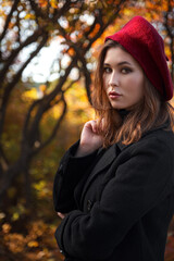 Beautiful young woman walking in the autumn forest