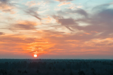 Natural Sunset Sunrise Over a forest or meadow. Bright beautiful sky and dark earth. Small clouds....