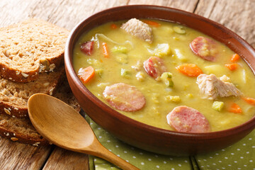 Classic Dutch pea soup erwtensoep, snert closeup in the plate on the table. horizontal