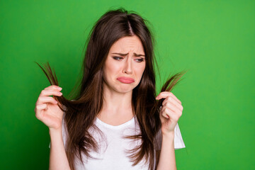 Photo of irritated sad woman wear casual outfit looking holding damaged hair arms isolated green...
