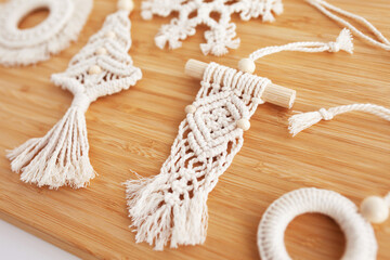 Fototapeta na wymiar Christmas macrame decor. Christmas present in the style of macramé. Natural materials - cotton thread, wood beads. Eco decorations, ornaments, hand made decor. Winter and New Year holidays