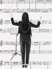 Young female conductor on white background with note signs