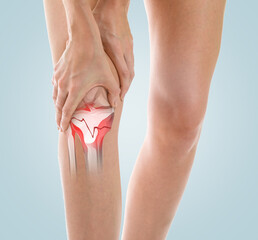 Young woman with broken leg suffering from pain on color background, closeup