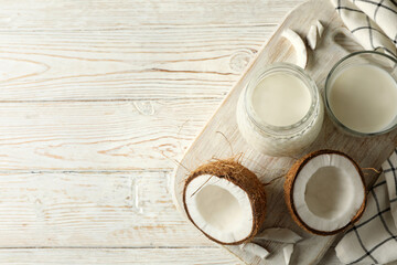 Board with fresh coconut and coconut milk on wooden background