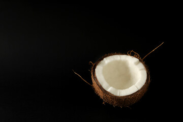 Half of fresh coconut on black background