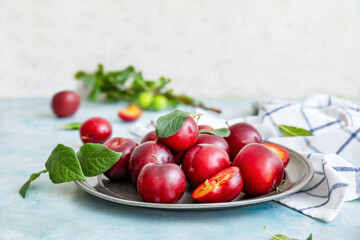 Plate with fresh ripe plums on  table