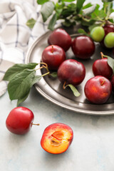 Plate with  fresh ripe plums on  table