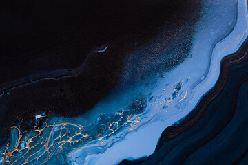 Obraz na płótnie Canvas Acrylic Fluid Art. Dark Blue waves in abstract ocean and golden foamy waves. Marble effect background or texture