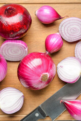 Fresh raw onion and knife on wooden board