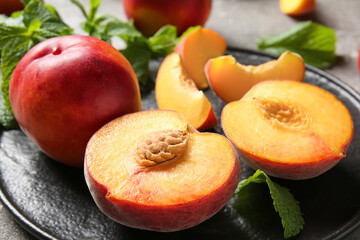 Fototapeta na wymiar Plate with sweet ripe peaches on table