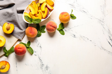 Composition with whole and cut ripe peaches on table