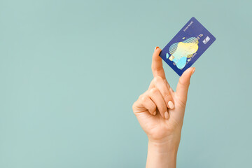 Female hand with credit card on color background