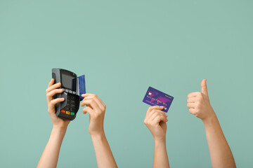 Female hands with credit cards and payment terminal on color background