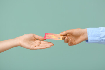 Female hands with credit card on color background