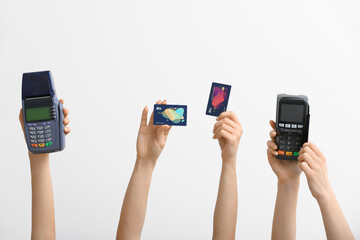 Female hands with credit cards and payment terminals on white background