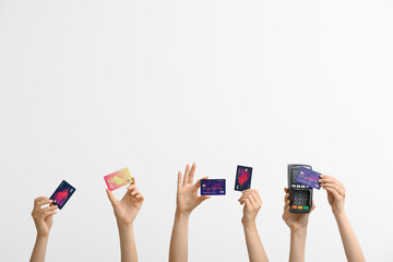 Female hands with credit cards and payment terminal on white background
