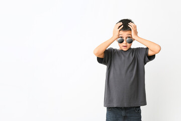 Shocked boy wearing stylish sunglasses against white background