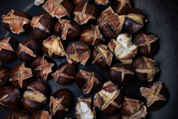 closeup shot to Chestnuts on a pan with black background