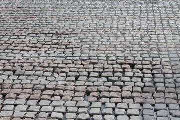 The pavement is made of small cobblestones in the form of square tiles. Texture background