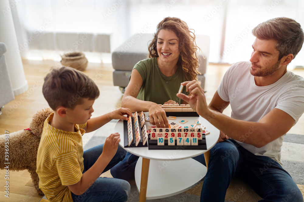 Wall mural happy family having fun, playing board game at home