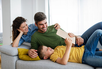 Happy family using technology devices together at home.