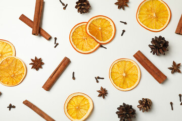 Cinnamon, orange slices and cones on white background
