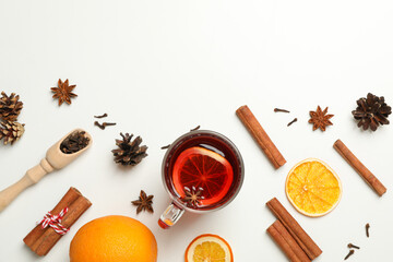 Cup of mulled wine and ingredients on white background