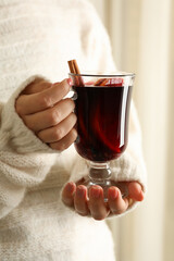 Woman in sweater hold cup of mulled wine
