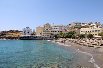 Fototapeta na wymiar Rows of umbrellas on the beach of Agios Nikolaos in Crete, Greece