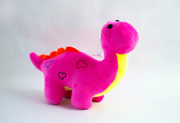Dragon plush doll, on white background with shadow reflection. Dragon plush stuffed doll on white background. Dino plush toy. Pink stuffed dinosaur toy