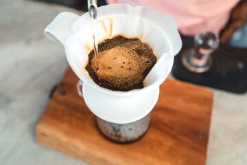 Drip coffee, barista pouring water on coffee ground with filter