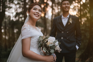 The newlyweds happy in the atmosphere of the pine forest, looking and feeling warm.