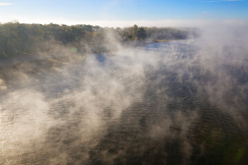 morning fog over the river embankment of the city