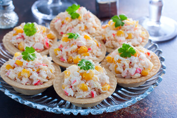 Celebratory tartlets with crab salad and corn on a glass dish and glasses of champagne, horizontal © Анна Журавлева