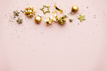 Flat lay of Celebration. Golden Christmas decorations on pink background